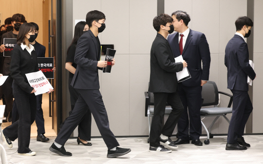 전공의들이 15일 오전 서울 용산구 대한의사협회에서 열린 '정책피해 전공의, 박민수 복지부 제2차관 직권남용 및 권리행사방해 혐의 집단고소 기자회견'에서 검은 옷을 입은 채로 손팻말을 들고 입장하고 있다.  [연합뉴스]